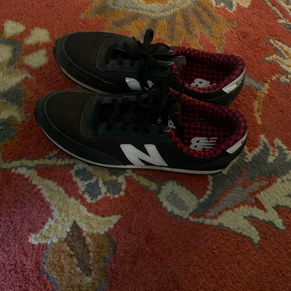 Black New Balance sneakers with black and red checked lining. Preowned